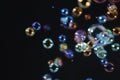 Beautiful fresness colorful soap bubbles floating in the dark. Black background. Royalty Free Stock Photo