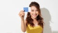 Beautiful friendly smiling confident girl showing blue card in hand, over white background Royalty Free Stock Photo