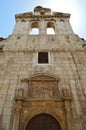 Beautiful Front Facade Of The Church Of Alcala De Henares University With A Nest Of Storks In Its Old Bell Tower. Architecture Tra Royalty Free Stock Photo