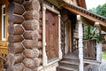 A beautiful front porch in a rustic log house and a wooden shuttered window. Rural culture and history, antique Royalty Free Stock Photo