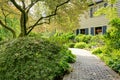 Beautiful front yard with walkway and grey brown large house.