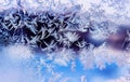 Beautiful frosty pattern with various ornate patterns on transparent glass on winter window