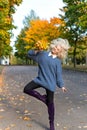 Beautiful fun happy blond girl jumping and having fun in autumn Park with a bouquet of bright colored leaves Royalty Free Stock Photo