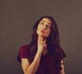 Beautiful fun humor grimacing smiling woman with long brown curly healthy hair style with hand under the face looking up and Royalty Free Stock Photo