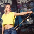 Urban lifestyle shot. Beautiful funky girl with skateboard