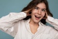 Beautiful funny amusing joyful cute nice adorable tender young curly brunette woman wearing white shirt isolated on blue