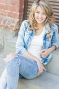 Beautiful funny blonde girl with big lips with a charming smile, wearing jeans and a white shirt walking in the city solnetsnym Royalty Free Stock Photo