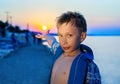 Beautiful funny child standing on beach at sunset on summer vacation