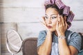 Beautiful and funny expression caucasian adult woman getting ready at home in front of the mirror with make up on the face - Royalty Free Stock Photo