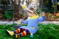 Beautiful funny little toddler girl with bunny ears having fun with traditional Easter eggs hunt on warm sunny day Royalty Free Stock Photo