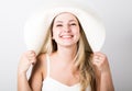 Beautiful funny young blonde woman in white tank top and a large white hat smiling Royalty Free Stock Photo