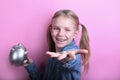 Beautiful funny young girl with silver piggy bank on pink background. save money concept. Royalty Free Stock Photo