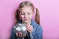 Beautiful funny young girl with silver piggy bank on pink background. save money concept. Royalty Free Stock Photo