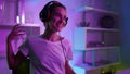 Beautiful gamer winning esport competition online in neon lights at home closeup