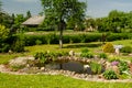 Beautiful garden with small waterlily pond and white duck in it in sunny summer day Royalty Free Stock Photo