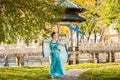 Beautiful geisha with a blue umbrella near green apple tree Royalty Free Stock Photo