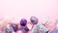 Beautiful gemstones and druses of natural purple mineral amethyst on a pink background. Amethysts and rose quartz. Large crystals Royalty Free Stock Photo