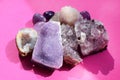 Beautiful gemstones,  geode of  amethyst and druses of natural purple mineral amethyst on a bright pink background. Amethysts and Royalty Free Stock Photo