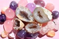 Beautiful gemstones,  geode amethyst and druses of natural purple mineral amethyst on a pink background. Amethysts and rose quartz Royalty Free Stock Photo