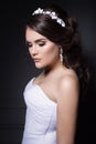 Beautiful gentle girl groom in a wedding dress with hairstyle and make-up, hair decorated with a wreath of flowers