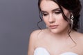 Beautiful gentle girl portraits of the bride in a white wedding dress with evening hairstyle with a rim of flowers in her hair and Royalty Free Stock Photo