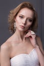 Beautiful gentle girl portraits of the bride in a white wedding dress with evening hairstyle with a rim of flowers in her hair and Royalty Free Stock Photo