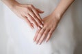Beautiful gentle hands of bride with neat manicure in white wedding dress with wedding ring on her hand. Bride touches Royalty Free Stock Photo