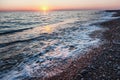 Beautiful gentle sunset at the sea, bright sun and pebble beach Royalty Free Stock Photo