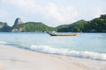 Beautiful gently waves on white sand beach. Soft sunlight. Traditional fishing boat and island background. Summer season. Mu Royalty Free Stock Photo