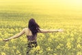 Beautiful genuine woman in sunny summer meadow from behind left