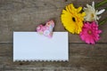 Beautiful gerberas floewrs with colored heart and white paper for your text on wood
