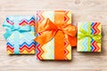 Beautiful gift box with a colored bow on the orange wooden table. Top view with copy space for you design. Christmas concept Royalty Free Stock Photo