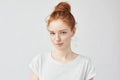 Beautiful ginger model with trendy bun biting lip.