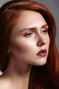 Beautiful ginger young woman with luxury hair style and fashion gloss makeup. Beauty closeup model with red hair Royalty Free Stock Photo