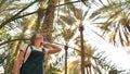 Beautiful girl against the background of palm trees in a park near the city of Al Ain. UAE. Royalty Free Stock Photo