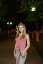 Beautiful girl in the alley in the park in the evening.