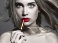 Beautiful girl Applying lipstick. young Woman putting red lipstick Royalty Free Stock Photo