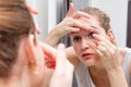 Beautiful girl applying or removing a contact lens with mirror Royalty Free Stock Photo