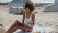 Beautiful girl applying suntan lotion on beach. Stylish woman sunbathing alone Royalty Free Stock Photo