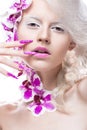 Beautiful girl with art make-up, flowers, curls and long nails. Manicure design. The beauty of the face.