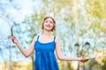 Beautiful girl-artist on the street in a blue dress, smiling, with tassels and palette in her hands Royalty Free Stock Photo