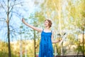 Beautiful girl-artist on the street in a blue dress, smiling, with tassels and palette in her hands Royalty Free Stock Photo