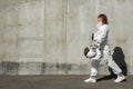 Beautiful girl astronaut without a helmet on the background of a gray wall. Fantastic space suit