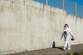 Beautiful girl astronaut without a helmet on the background of a gray wall. Fantastic space suit