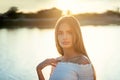 Beautiful girl in background of sunset. Portrait of young pretty model in nature. High quality photo
