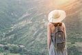 Beautiful girl with a backpack and a hat standing against a back Royalty Free Stock Photo