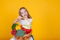 Beautiful girl with a basket of fresh vegetables, radishes, broccoli, tomato pepper