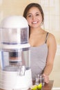 Beautiful girl behind a filter system of water purifier on a kitchen background