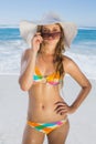 Beautiful girl in bikini and straw hat looking at camera on beach Royalty Free Stock Photo