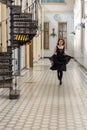 Beautiful girl in black dress running in hall checkered floor Royalty Free Stock Photo